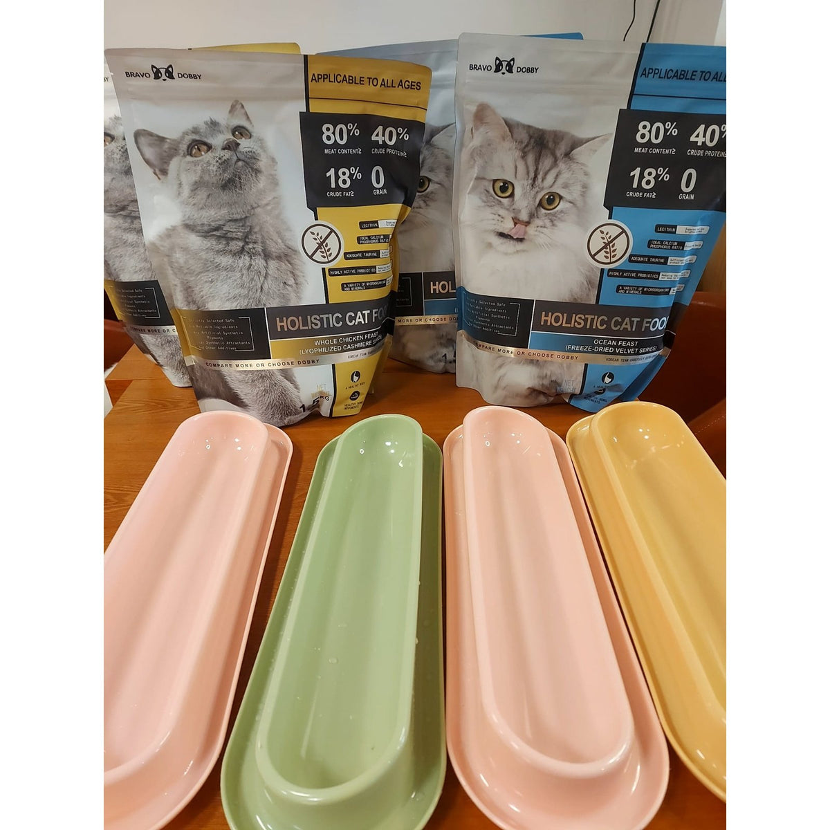Bravo Dobby cat food bags displayed behind pastel feeding trays