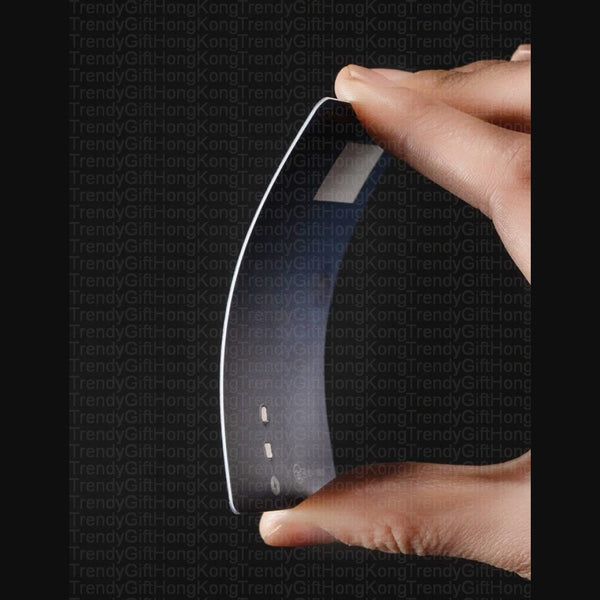 fingers bending a thin black card-shaped device, white border and rectangular surface markings