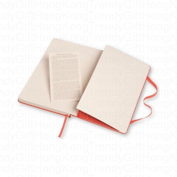 Red Moleskine notebook opened beside its printed information leaflet