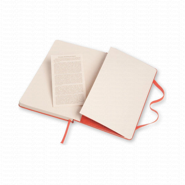 Red Moleskine notebook opened beside a printed information leaflet
